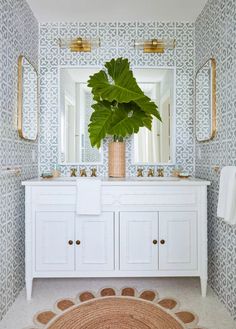 a bathroom with a large plant in the middle of it and two mirrors on the wall