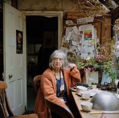 an older woman sitting at a table with food