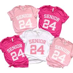 "Senior 2024 Shirt Group Shirt For Girls. \"Elevate your senior year in style with our Senior 2024 group t-shirts for girls! These shirts are more than just fabric; they're a symbol of the incredible journey you've embarked upon. Crafted for comfort and designed with a touch of trendiness, our Senior 2024 collection lets you wear your status proudly. Whether you're gearing up for graduation or simply want to capture the essence of this pivotal year, our t-shirts blend fashion and sentiment seamlessly. Make your senior year memorable with the Senior 2024 collection - where every shirt tells a story of triumph!\" T-Shirt: ☆100% Airlume combed and ringspun cotton (fiber content may vary for different colors) ☆Light fabric (4.2 oz/yd² (142 g/m ☆Retail fit ☆Tear away label ☆Runs true to size" Varsity Tops With Team Name For College Events, Collegiate Tops For College Events, Pink Team Name Tops For Team Events, Pink Tops With Team Name For Team Events, Varsity Short Sleeve Tops For Team Events, Sporty Tops With Team Name For College Events, Varsity Style Short Sleeve Tops For Team Events, Collegiate Pink Short Sleeve Tops, School Spirit Tops For Team Events