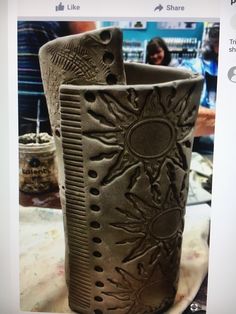 two vases sitting on top of a table with people in the background behind them