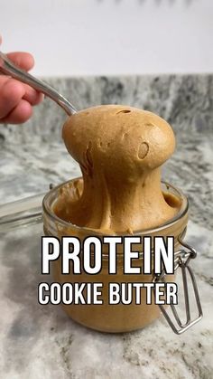 a person scooping out some cookie butter into a glass bowl with a spoon in it