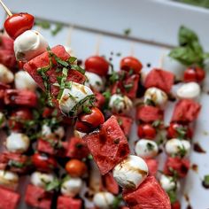 watermelon and mozzarella skewers on a white platter with toothpicks