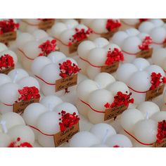 rows of white eggs with red flowers on them and brown tags attached to the sides