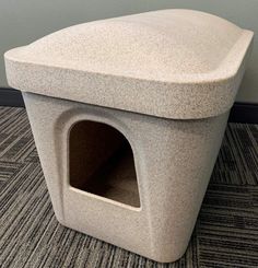 a dog house made out of concrete on the floor in an office building with carpeting