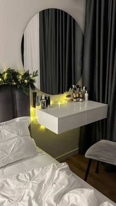 a white bed sitting next to a mirror on top of a dresser under a christmas tree