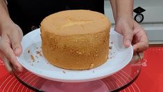 a person holding a plate with a cake on it