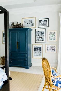 a bedroom with pictures on the wall and an armoire