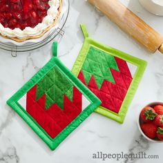 two quilted pot holders with strawberries on them