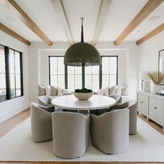 a large round table surrounded by chairs in a living room