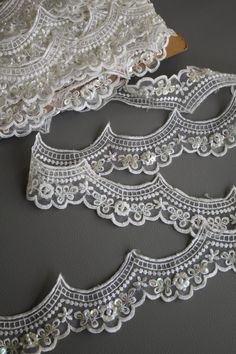 three pieces of white lace sitting on top of a table