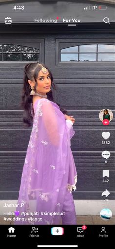 a woman wearing a purple dress standing in front of a garage door