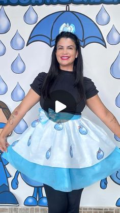 a woman in a blue and white dress with an umbrella on her head is posing for the camera