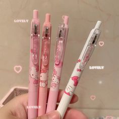 three hello kitty pens are in the palm of someone's hand and they have pink ink on them