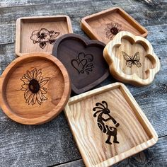 four wooden trays with different designs on them