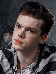 a young man with blue eyes wearing a striped shirt