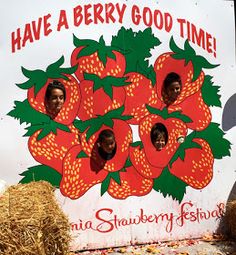 there is a sign that says have a berry good time with straw bales in front of it