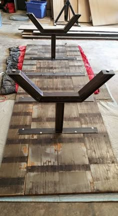 a bench made out of old pallets and wood planks is sitting on the ground