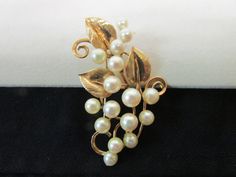 "Vintage Estate Ming's of Honolulu Mid Century 14K 16 High Luster Pearl With Leaf and Curl Gold Design Brooch Weight: 11.4 grams Brooch Size: 56.5 mm X 40.5 mm or 2 7/32\" inches X 1 19/32\" inches approx 16 Pearls: 5.5 mm -6.5 mm approx Height : 11.5 mm approx Marked: Ming's 14K Vintage Estate Ming's of Honolulu Mid Century 14K Pearl Brooch Older Ming's of Honolulu Pearl Brooch with Ming's Gold Work with Leaf and curls. Has Ming's Distinctive Gold Design Mings used in Their Jewelry Piece. 16 Hi Heirloom White Brooch For Formal Occasions, Heirloom Style White Brooch For Formal Occasions, Heirloom White Brooches For Formal Occasions, Gold Work, Pearl Brooch, Gold Design, Honolulu, Jewelry Pieces, Pearl Earrings