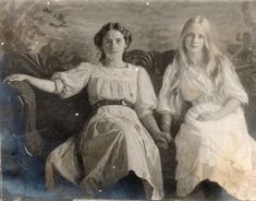 two women sitting next to each other on a couch