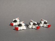 three legos sitting on top of each other in front of a gray background with red and white blocks