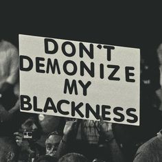 a protester holding a sign that says don't demonize my blackness