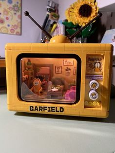 a yellow toy tv sitting on top of a table