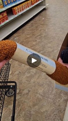 a person is holding a stuffed animal in a cart at the grocery store and it looks like they are trying to eat something