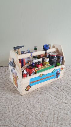 a wooden box filled with assorted items on top of a white carpeted floor