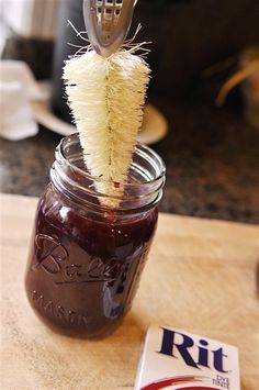 a jar filled with jam and a brush sticking out of it