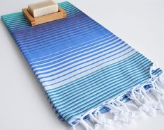 a blue and white towel with a wooden block on it