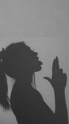 a black and white photo of a woman holding her hands up