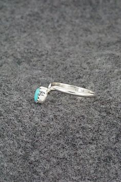 This simple yet elegant turquoise and sterling silver ring was made by Navajo silversmith Hiram Largo. The inside of the band is stamped sterling. (Please note: the stone color may vary slightly from the photos.)Size: 9.5Stone Length: 1/4"Stone Width: 3/16"Free shipping on all orders! We ship with USPS and always include tracking. All orders ship within a day of payment.Returns are accepted up to 30 days after you receive your order. Just send us a message. Our shop offers cash back or store credit. The item must be returned in new condition. Southwestern Sterling Silver Turquoise Ring For Anniversary, Turquoise Opal Ring In Sterling Silver, Silver Turquoise Open Ring Promise Ring, Nickel-free Open Turquoise Promise Ring, Untreated Turquoise Sterling Silver Ring For Anniversary, Untreated Turquoise Ring In Sterling Silver For Anniversary, Southwestern Sterling Silver Teardrop Ring, Hallmarked Turquoise Sterling Silver Ring For Anniversary, Silver Turquoise Open Ring For Anniversary