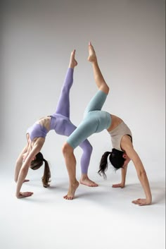 two women doing yoga poses on their hands