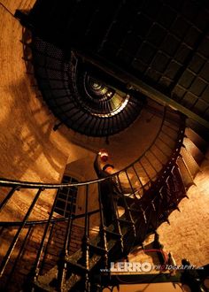 a man is standing at the top of a spiral staircase