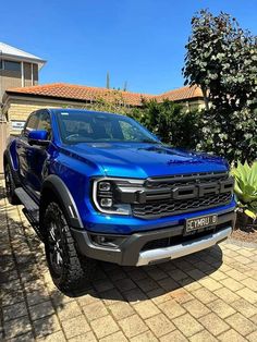 a blue truck parked in front of a house