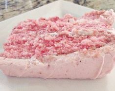 a piece of pink cake sitting on top of a white plate