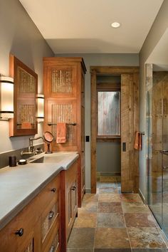 a large bathroom with wooden cabinets and marble counter tops, along with a walk in shower