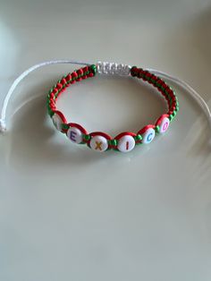 two beaded bracelets sitting on top of a white table next to each other