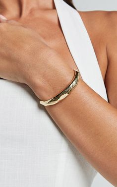 Add a touch of luxury to your wristwear collection with the Marcia Bangle in Gold. This open bangle is perfect for adding some casual elegance to any outfit. Made from high-quality gold, this bracelet exudes sophistication and complements a wide range of styles. Whether you're going for an understated look or want to make a statement, the Marcia Bangle is sure to elevate your accessory game effortlessly. Embrace the wristwear trend and complete your ensemble with this must-have piece today!Produ Luxury Gold Openable Bangle, Open Bangle, Stylish Bracelet, Casual Elegance, Everyday Wear, Bangles, Bracelet, Gold