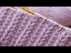 two balls of yarn are sitting next to each other on a table with knitting needles