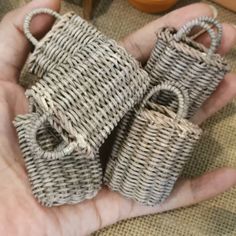 two small baskets are held in the palm of someone's hand