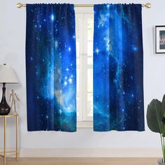 the curtains in this room are blue with stars on them and there is a plant next to it