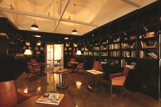 the library is full of books and leather chairs