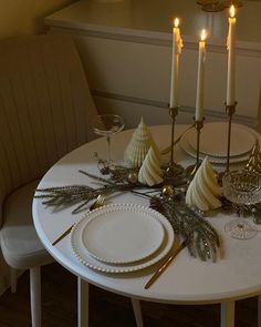 a white table topped with plates and candles