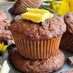 chocolate muffins stacked on top of each other with butter and chocolate chips around them