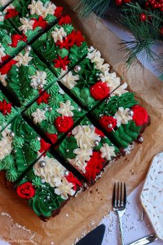 there is a square cake decorated with red, white and green frosting on the table