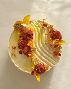 a piece of cake with white frosting and orange flowers on the top, sitting on a table