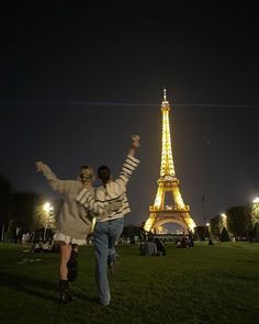 a man and woman are dancing in front of the eiffel tower at night