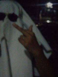 a person in a white robe holding up two fingers