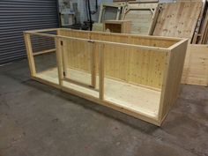 a large wooden box sitting on top of a floor next to other wood boxes in a warehouse